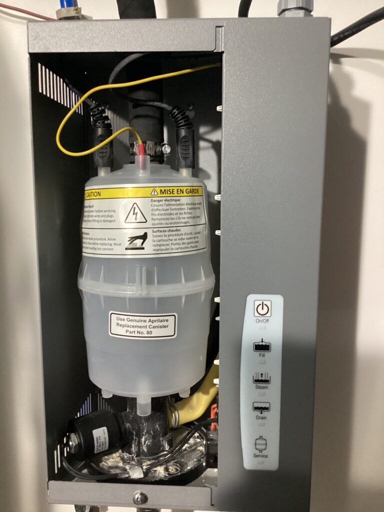 Here is a close-up of a whole-home humidifier unit with a translucent water canister.